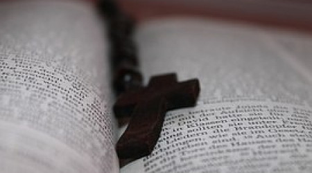 Buch aufgeschlagen mit Kreuz