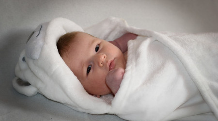 Baby - in weisse Decke eingewickelt