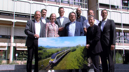 Die Projektbeteiligten halten vor dem Landratsamt ein Bild der Zollern-Alb-Bahn hoch